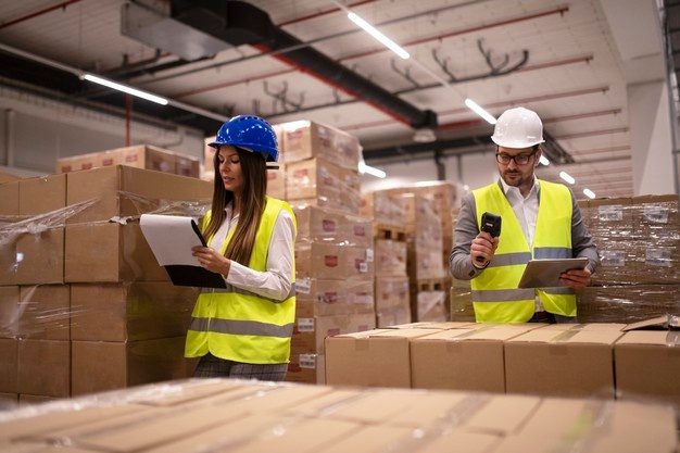 warehouse-workers-using-bar-code-scanner-tablet-checking-goods-inventory_342744-1489